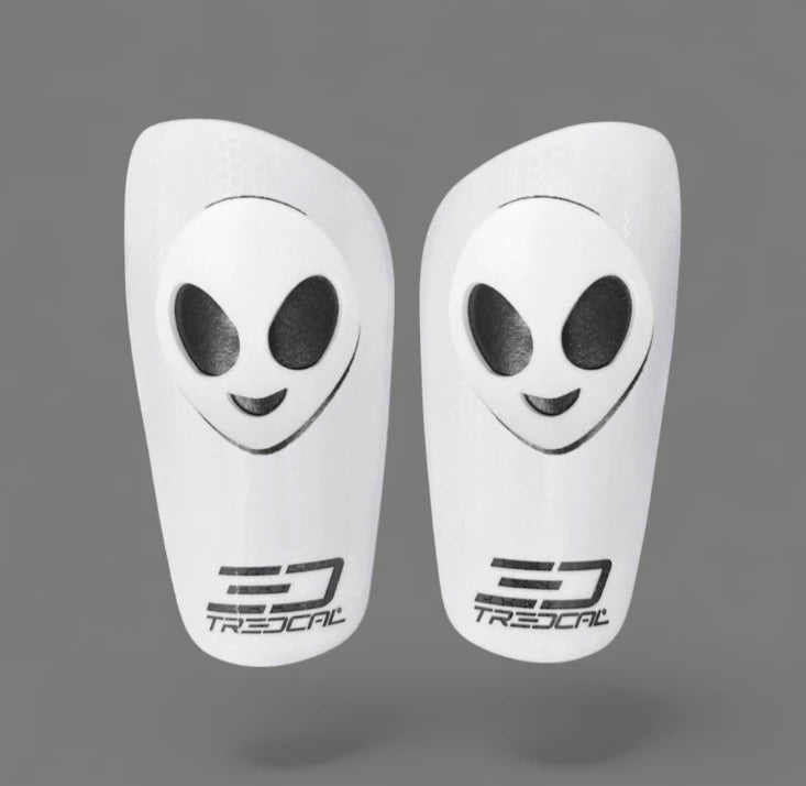 A pair of TREDCAL brand soccer shin guards with patented 3D alien logo.