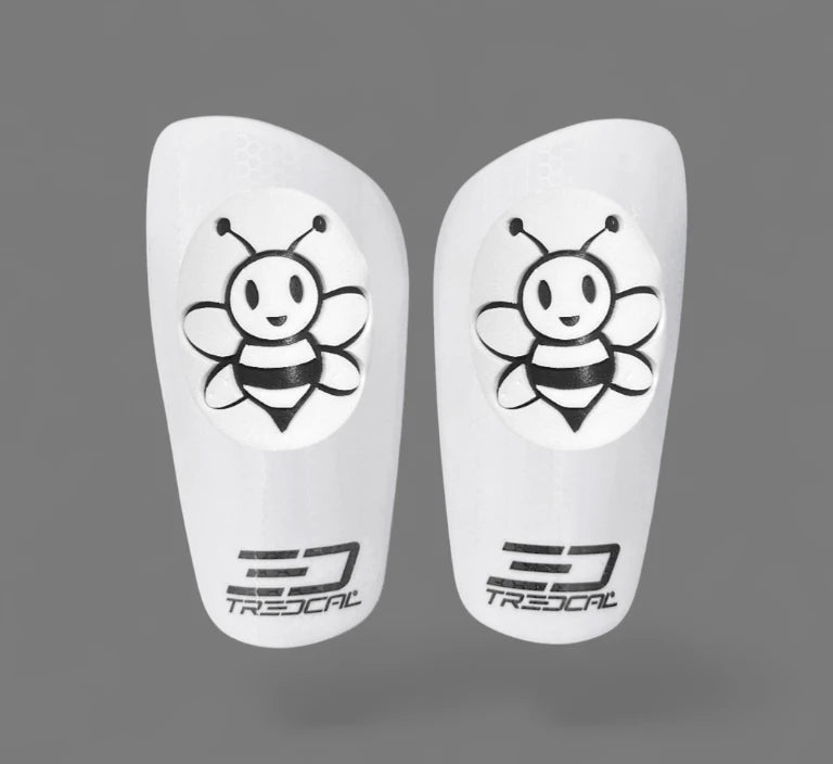 Pair of white shin guards with 3D bee design and Tredcal logo