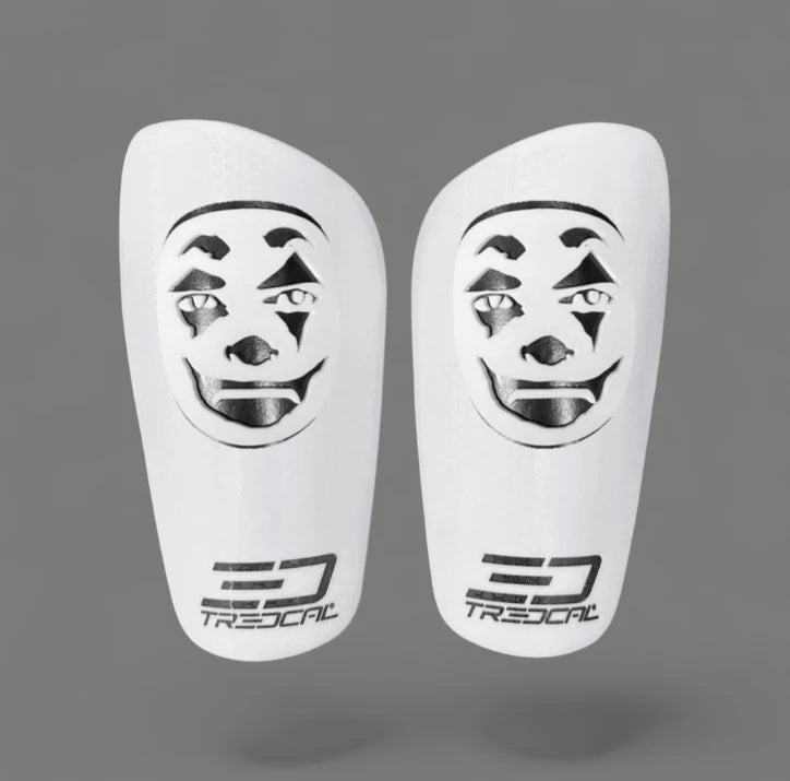 A pair of TREDCAL brand soccer shin guards with patented 3D clown face logo.