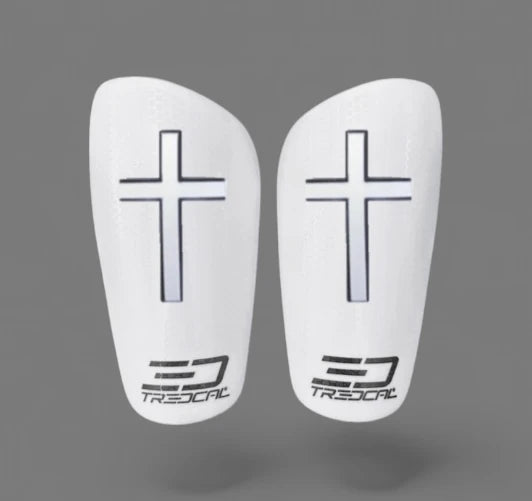 A pair of TREDCAL brand soccer shin guards with patented 3D cross logo.