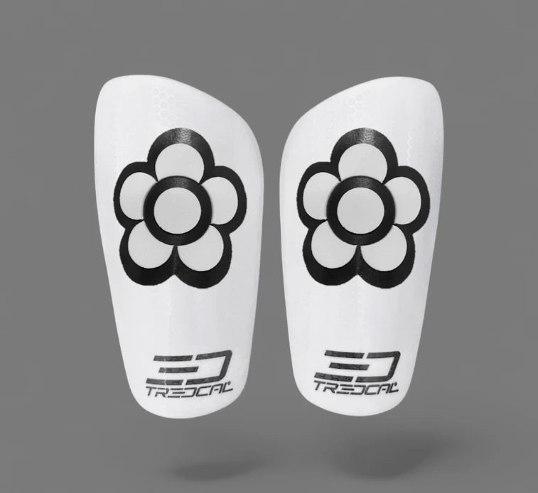 Pair of white shin guards with black flower designs and Tredcal branding 