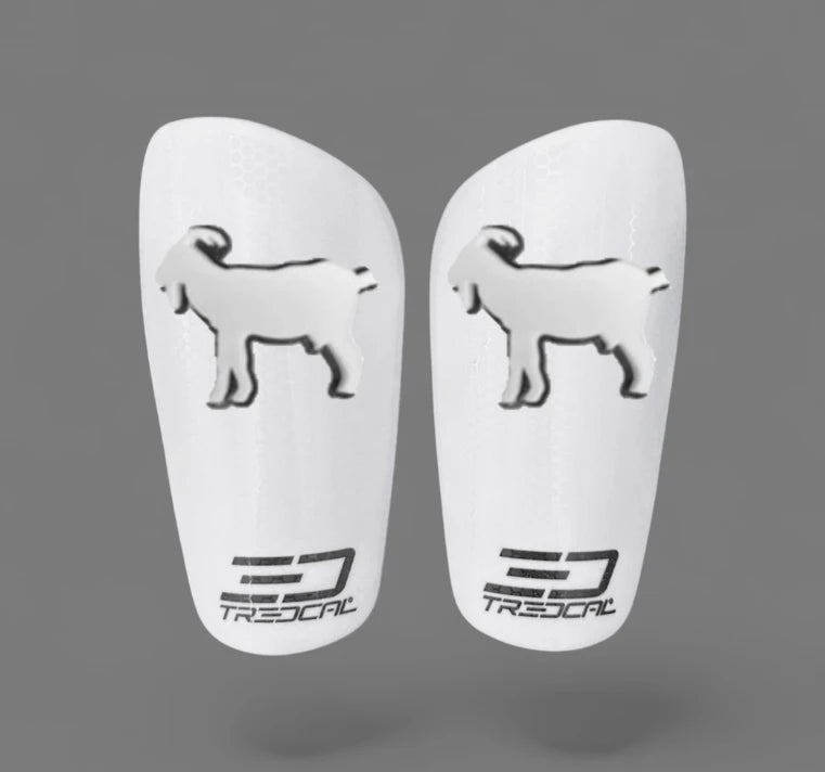 A pair of TREDCAL brand soccer shin guards with patented 3D GOAT logo.