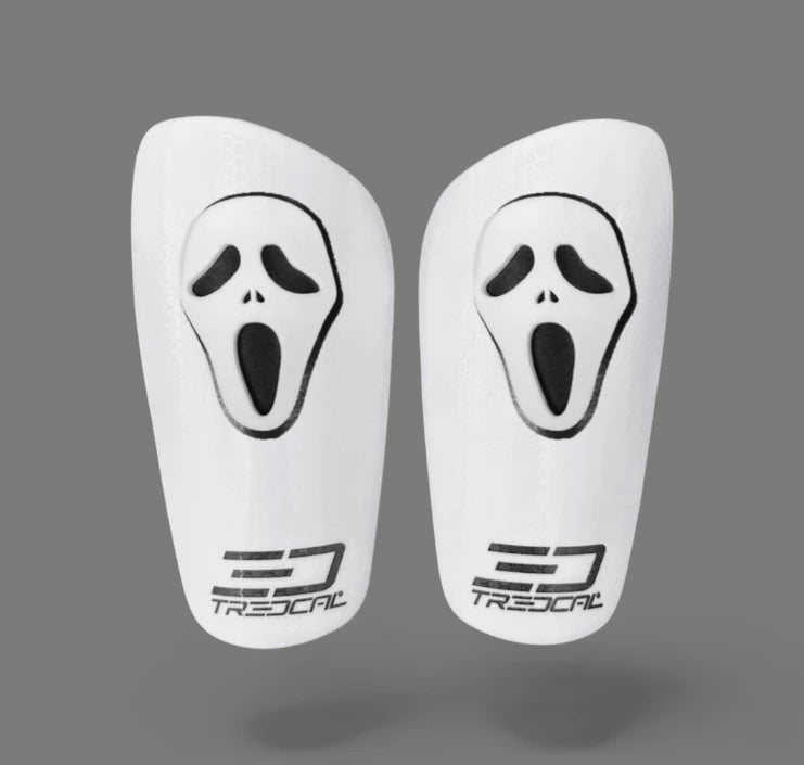 White shin guards with black 'scream' face design and Tredcal logo