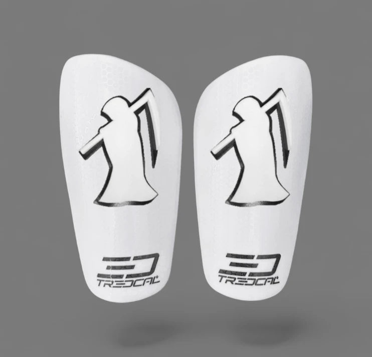 A pair of TREDCAL brand soccer shin guards with patented 3D grim reaper logo.