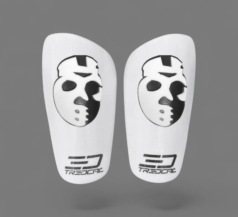 A pair of TREDCAL brand soccer shin guards with patented 3D hockey mask logo.