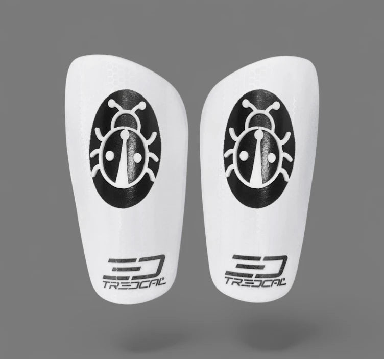 A pair of TREDCAL brand soccer shin guards with patented 3D lady bug logo.