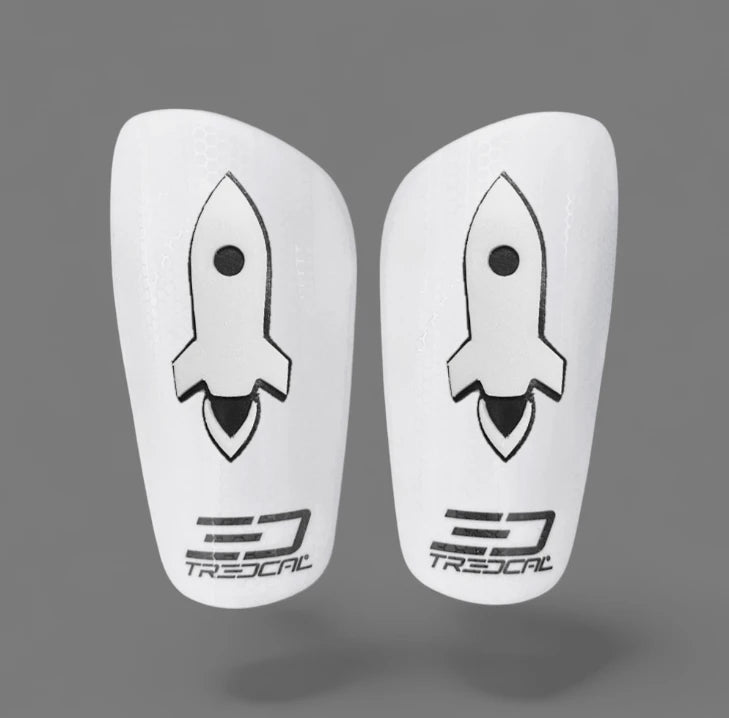 Pair of white shin guards with 3D rocket design on TREDCAL shin guards