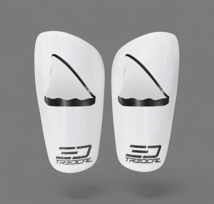 A pair of TREDCAL brand soccer shin guards with patented 3D shark fin logo.