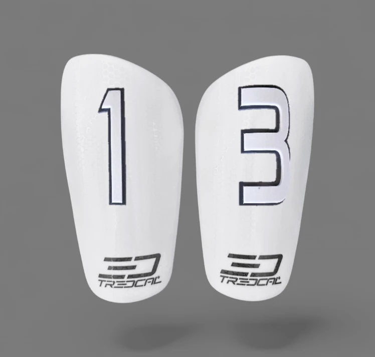 Pair of white shin guards with 3D white and black numbering and TREDCAL branding