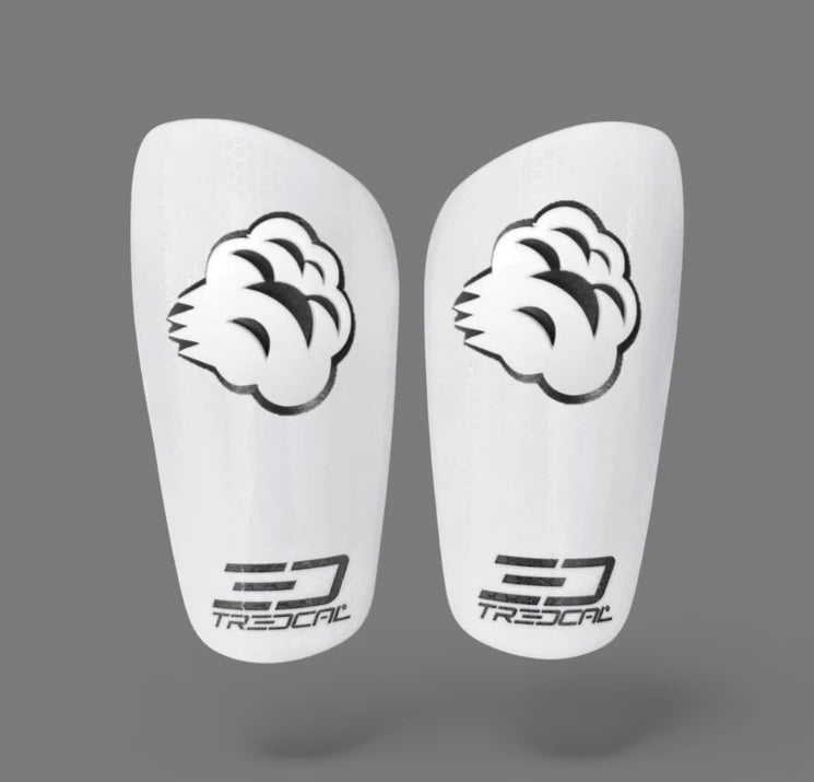 Pair of white soccer shin guards with 3D logos on TREDCAL guards