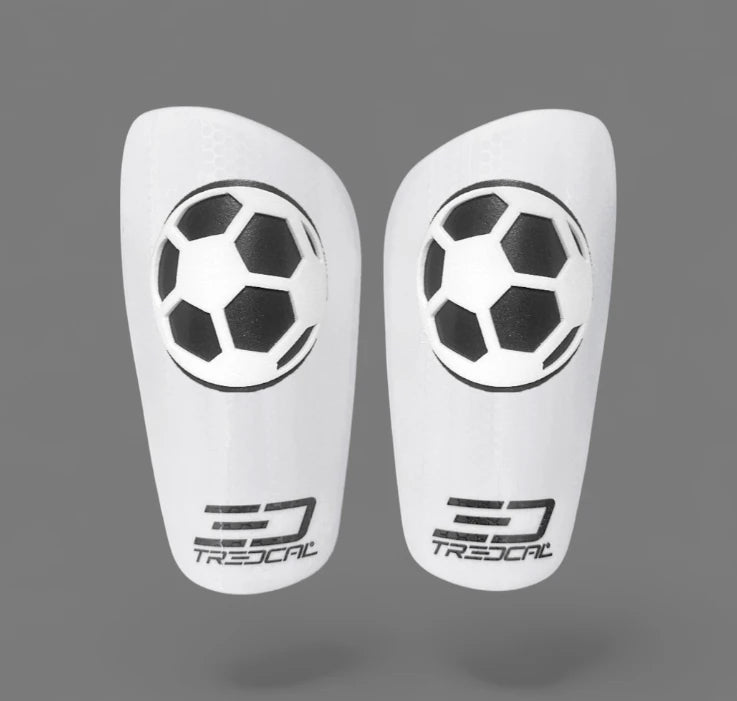 A pair of TREDCAL brand soccer shin guards with patented 3D soccer ball logo.